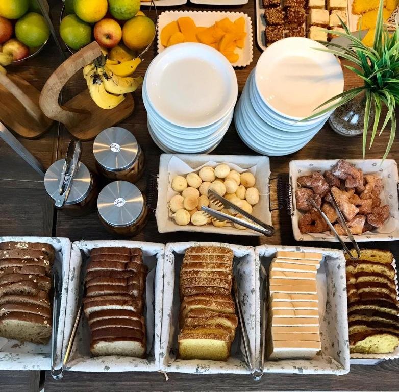 Cestos com diversos tipos de pães, bolos e pão de queijo no café da manhã