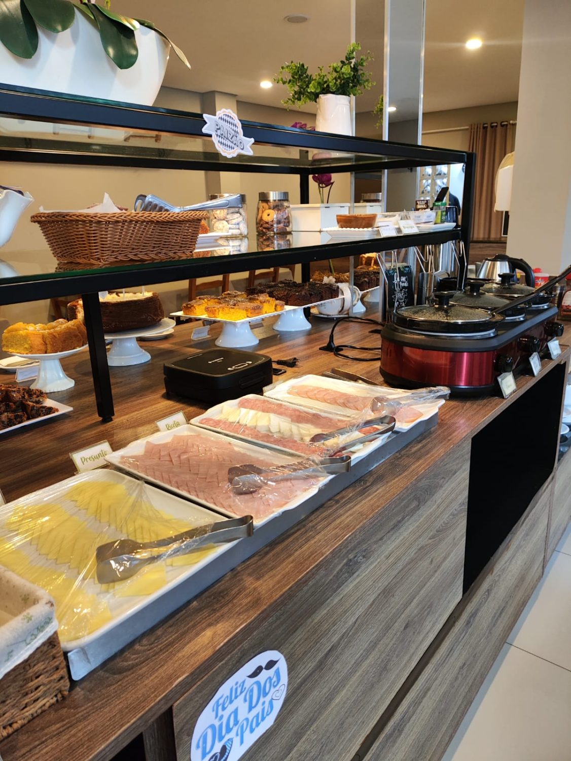 Frios, queijos e bolos — café da manhã do Hotel Lorimar