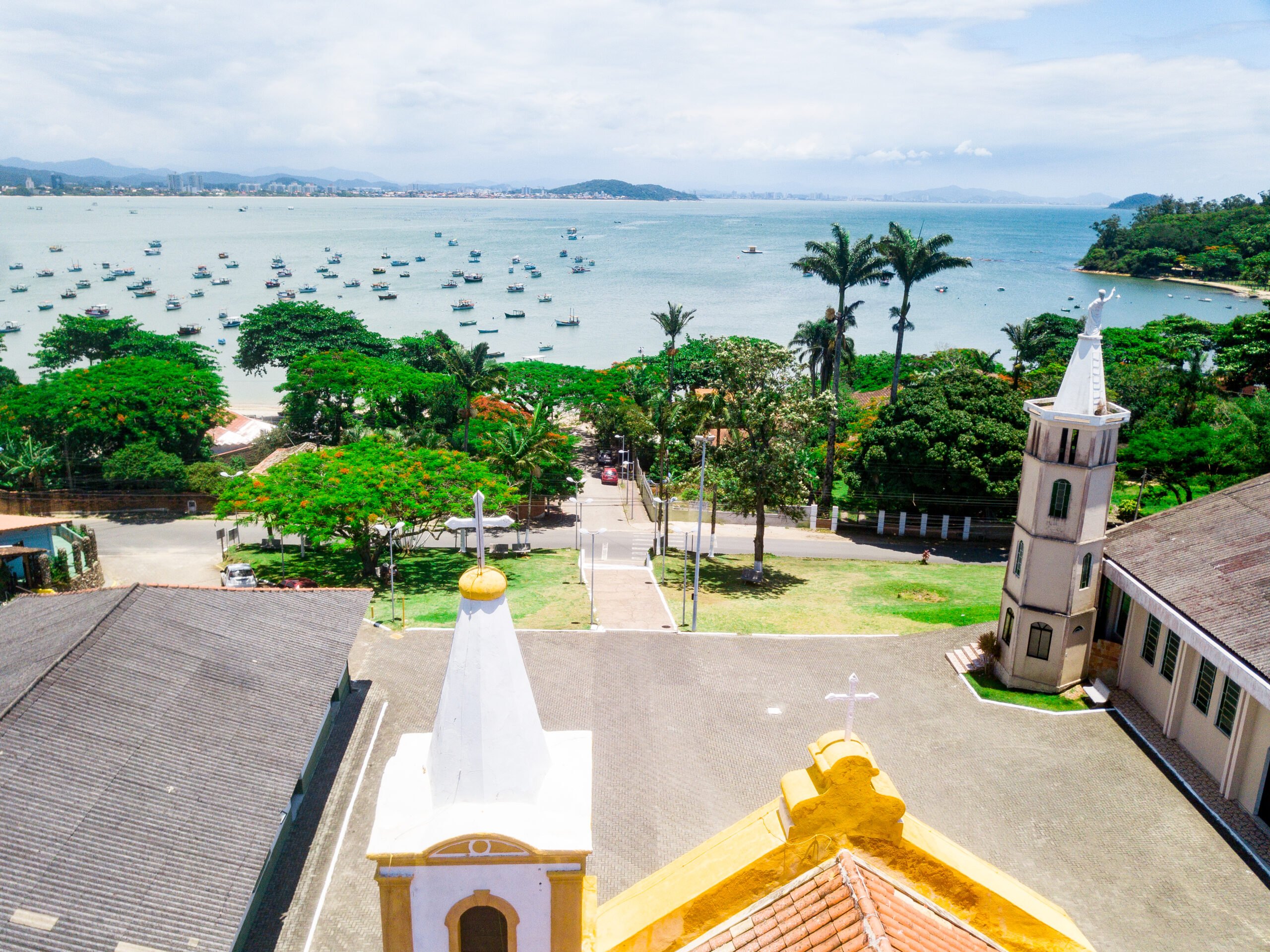 Vista aérea da Capela São João Batista com a enseada de Penha e os barcos de pesca ao fundo