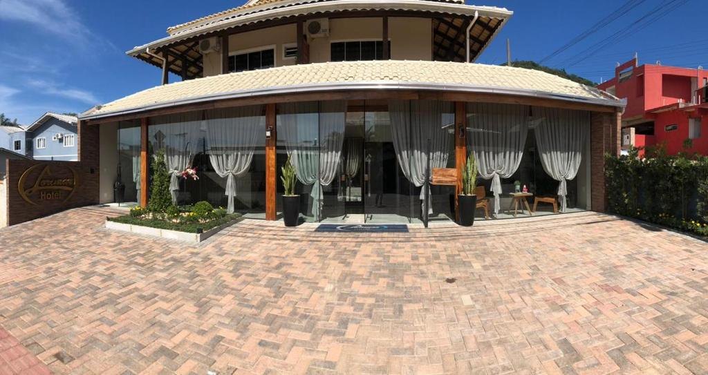 Fachada do Hotel Lorimar durante o dia, com cortinas claras e arquitetura aconchegante